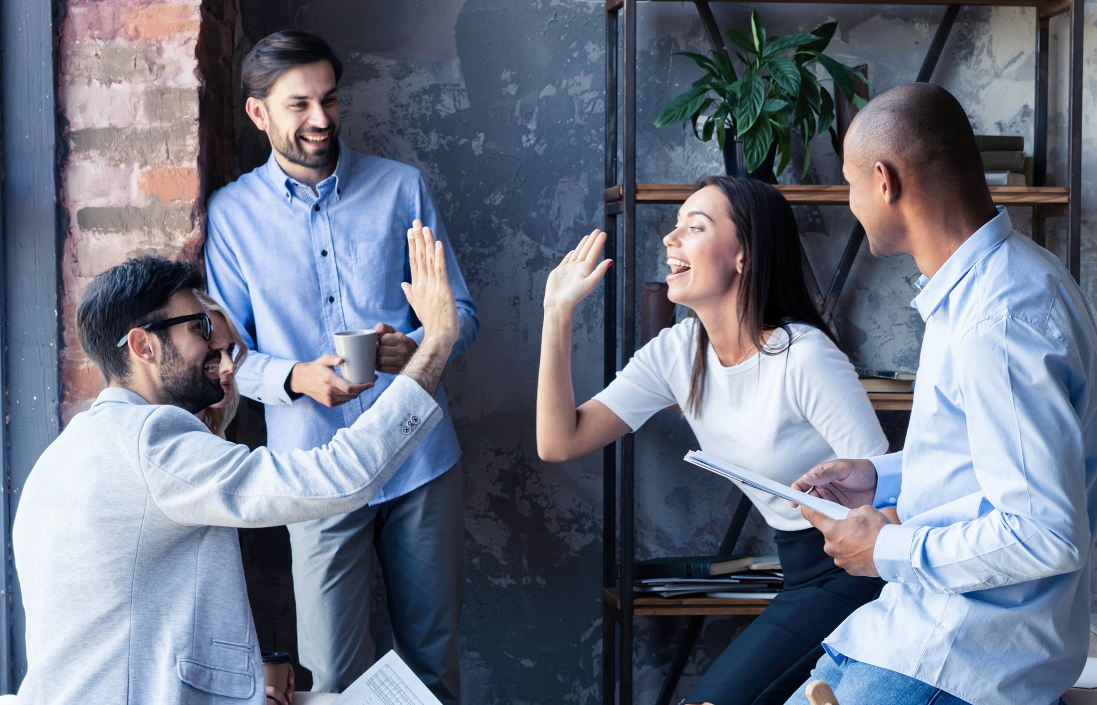 group of young professionals high five 