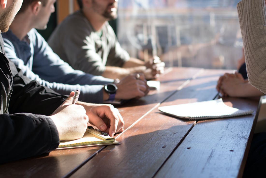 Group of people taking notes at a table