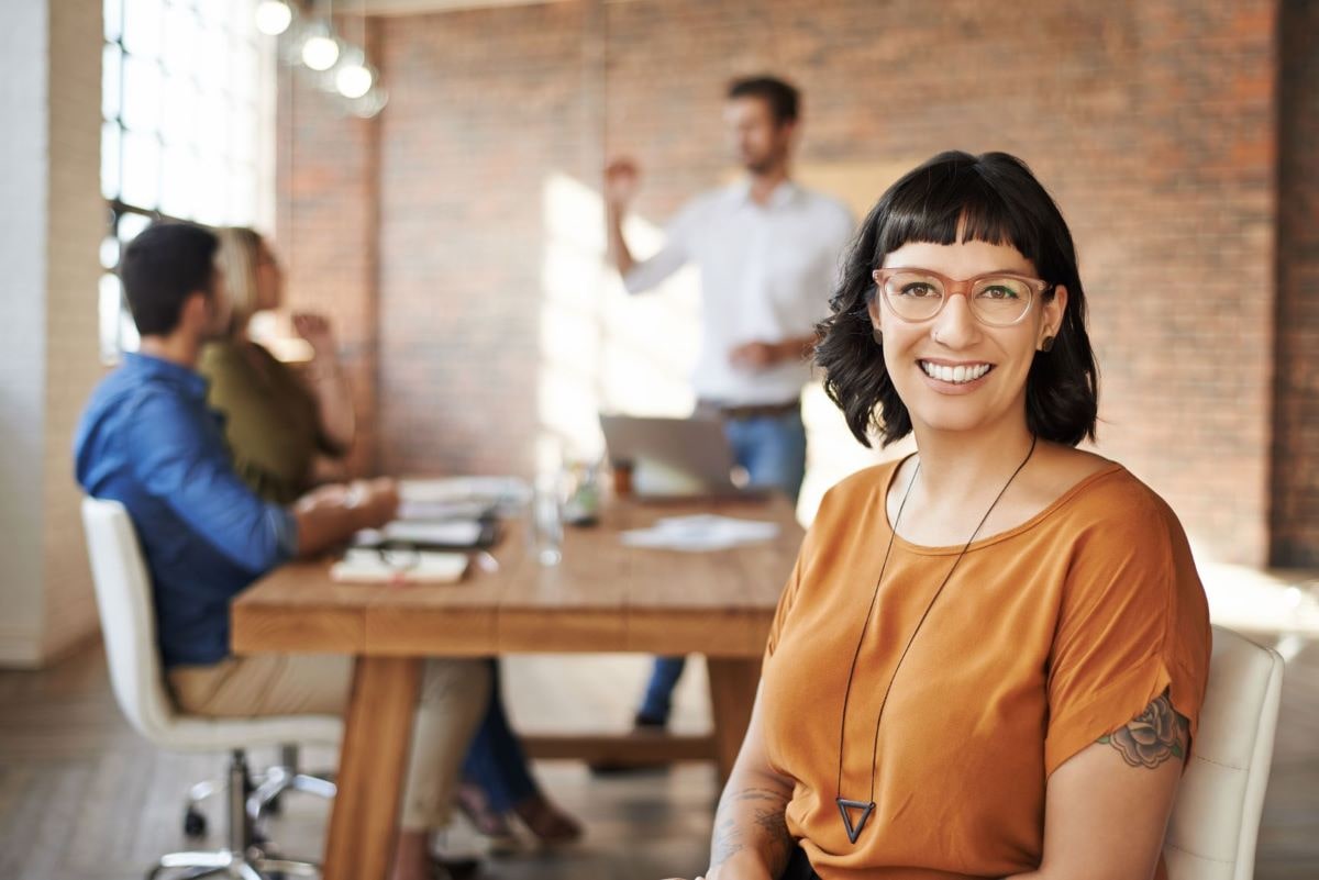 Femme à lunettes au bureau et souriante