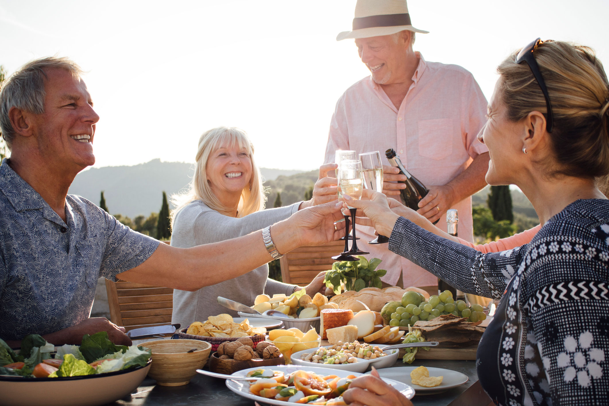 group of seniors smiling cheering with a drink and food