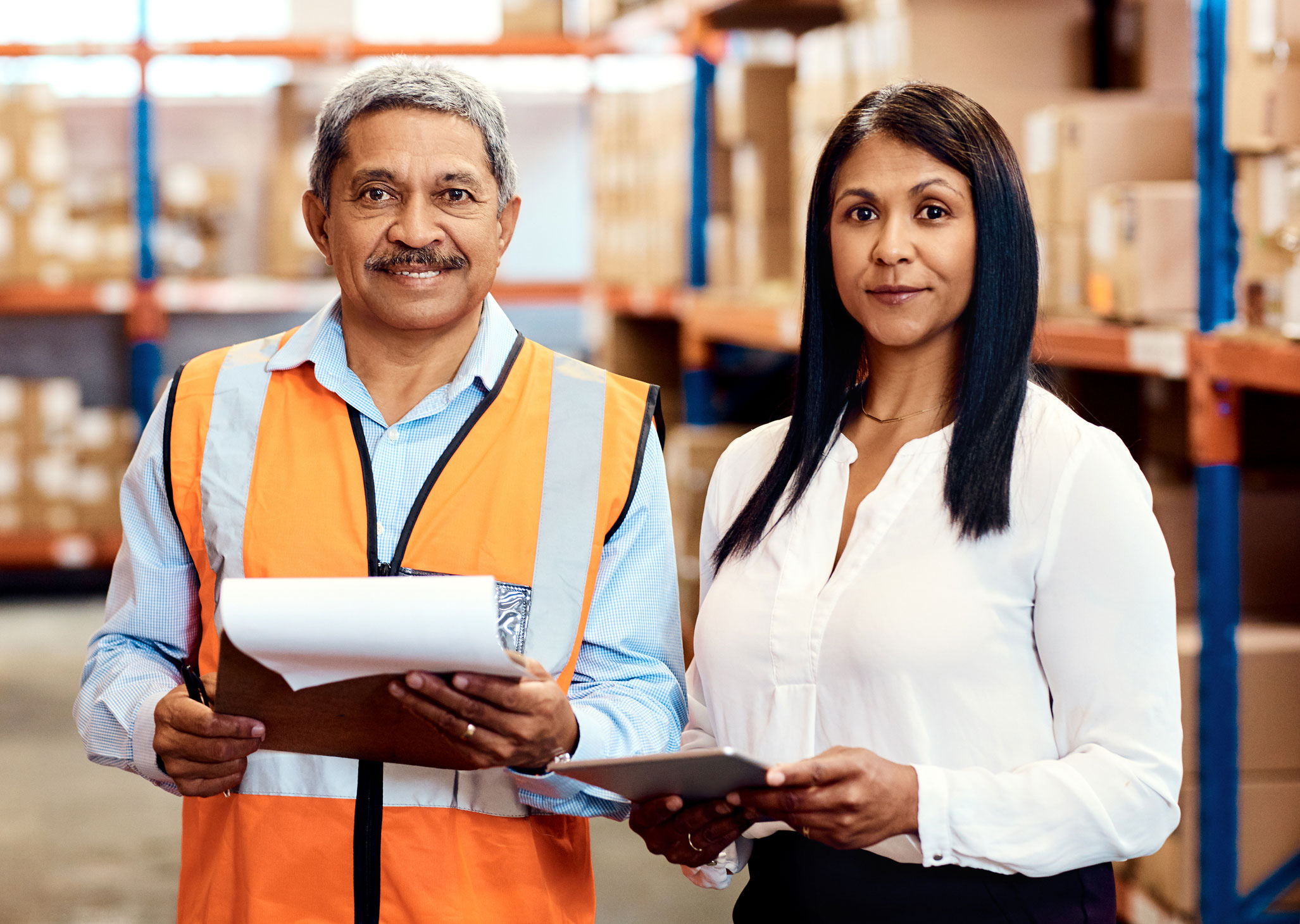 Two coworkers standing together in a warehouse