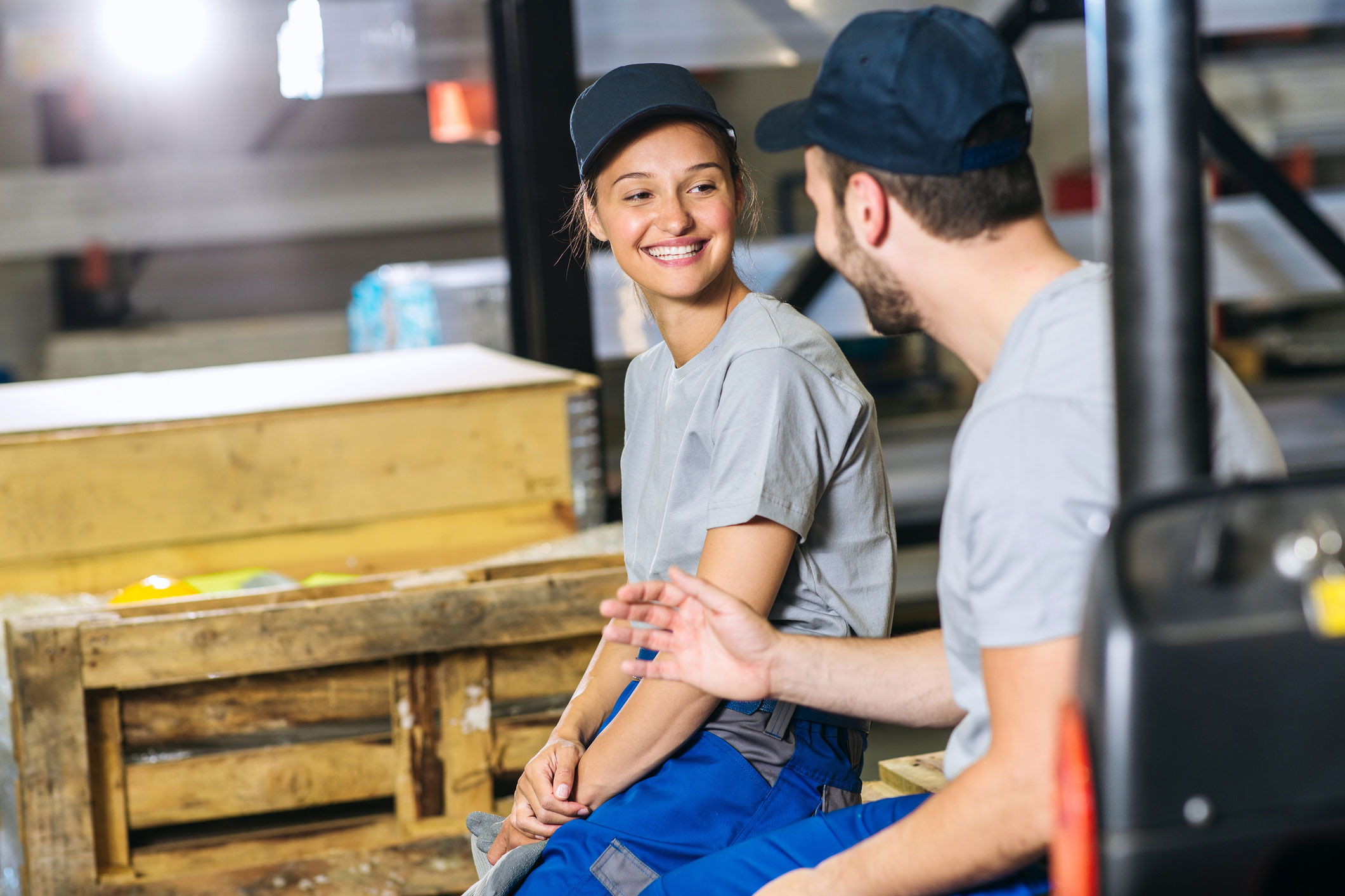 Two smiling coworkers on the factory floor