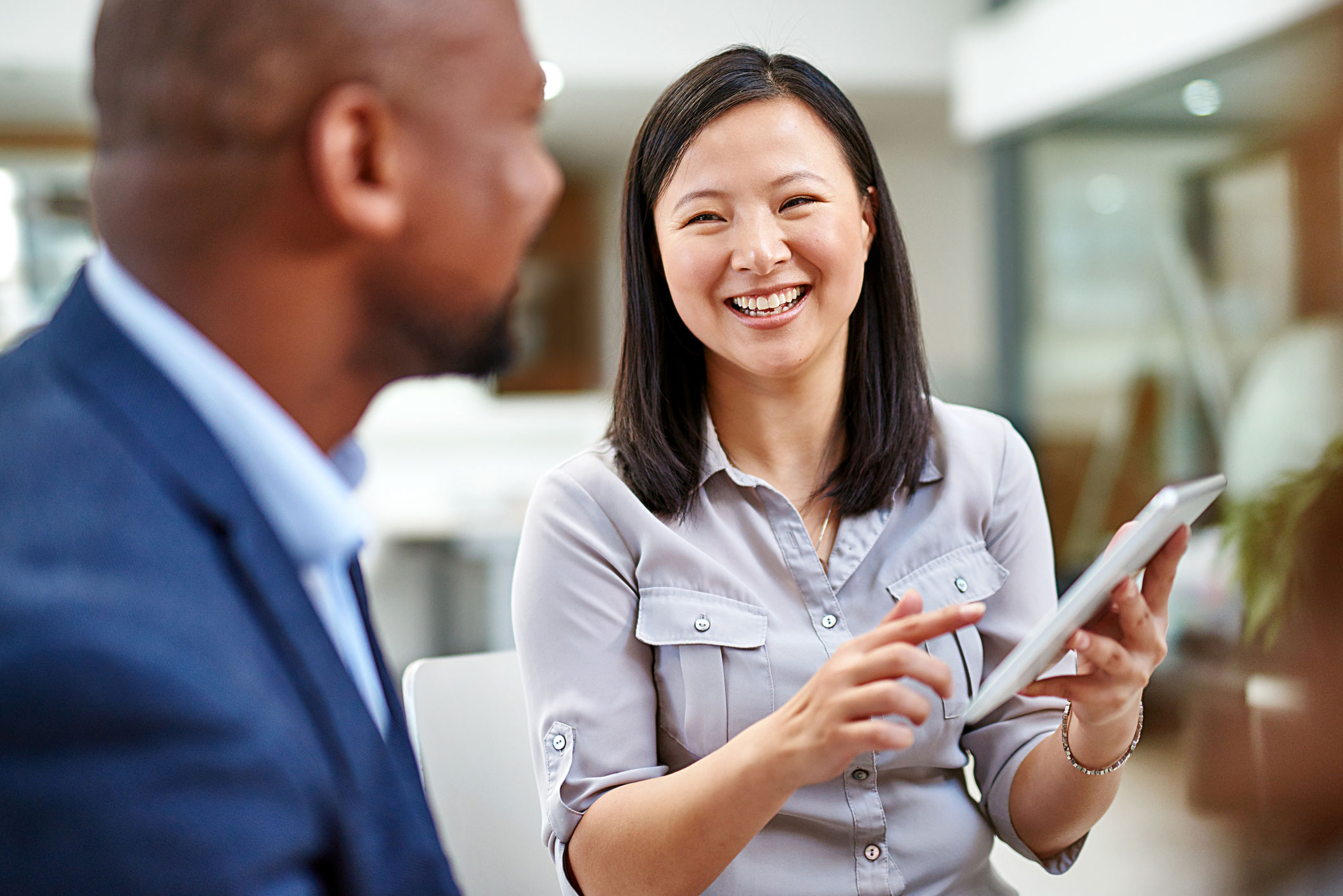 Deux employés souriants en discussion de travail