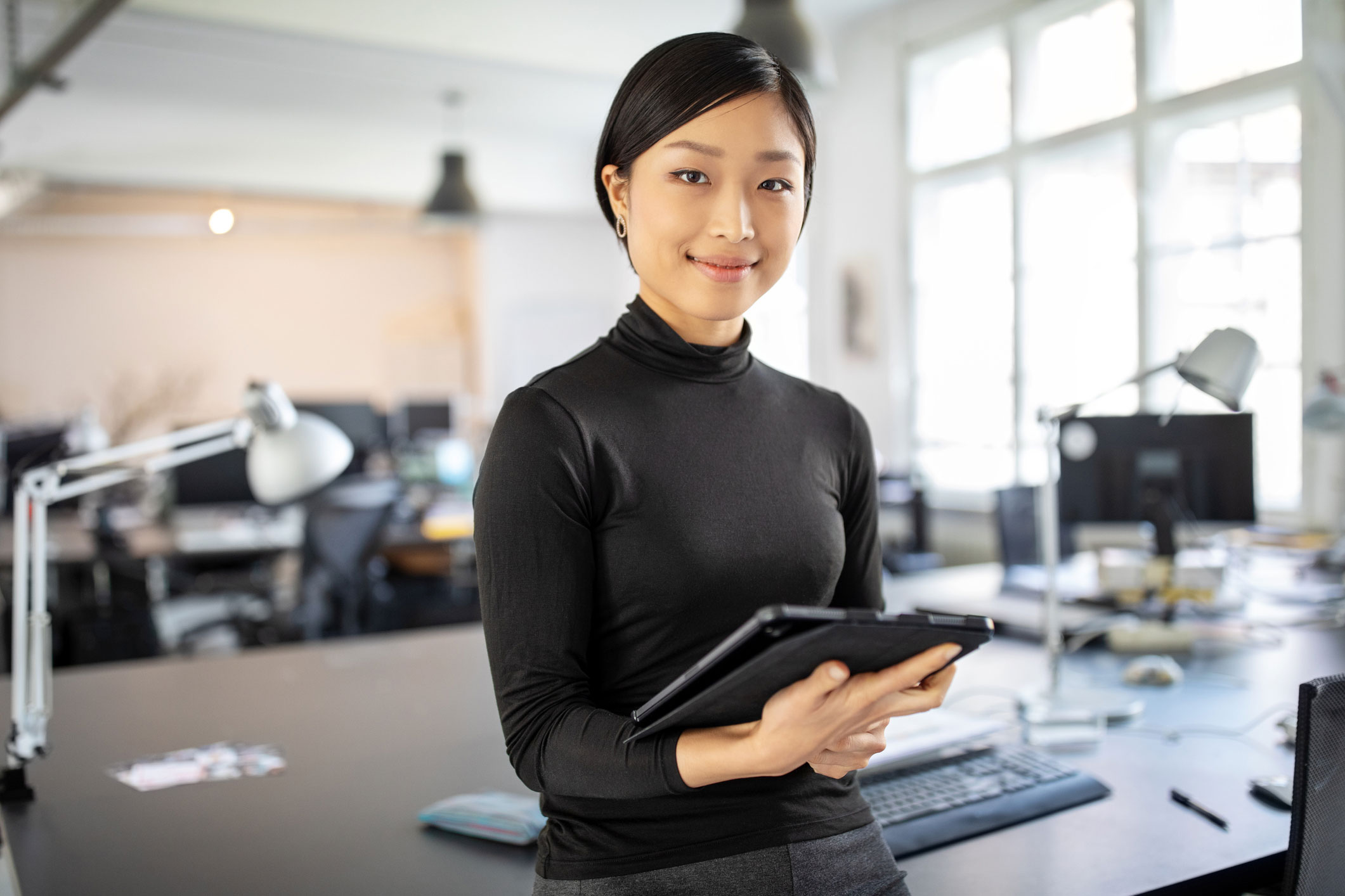 Young professional woman holding a tablet and smiling