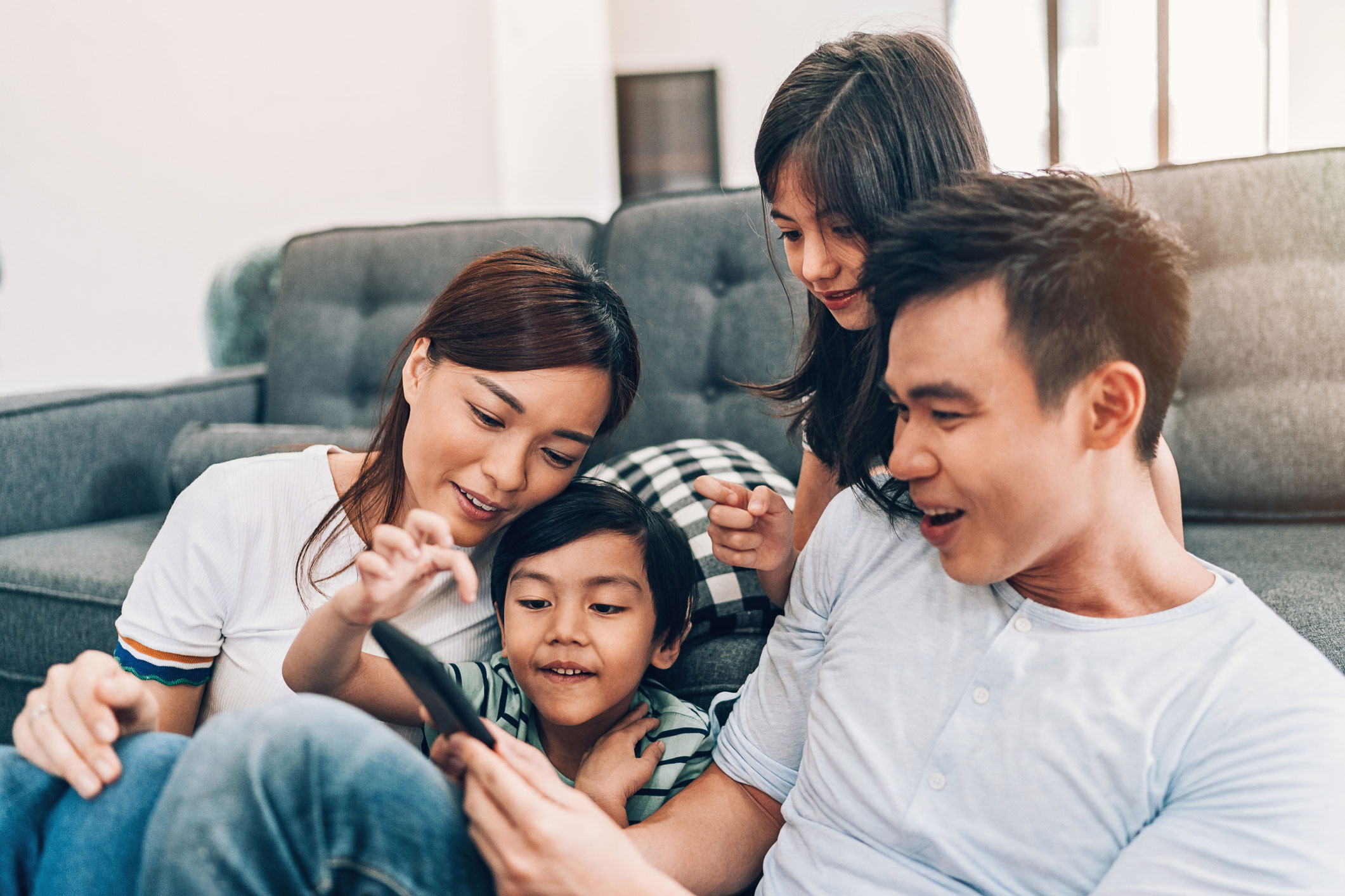 Young family viewing dad's mobile phone.