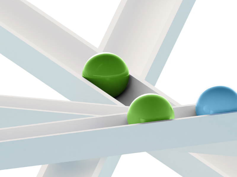 Close-up of green and blue spheres resting on intersecting angled beams.