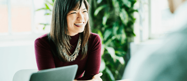 A smiling woman sits in an interview.