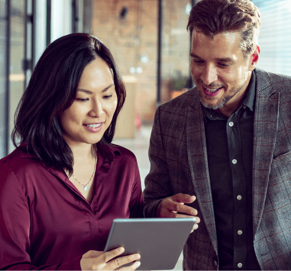 Two colleagues look at a tablet.