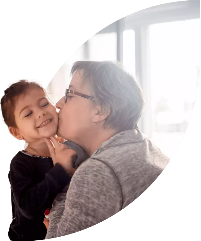 Grandmother gives a kiss to her granddaughter