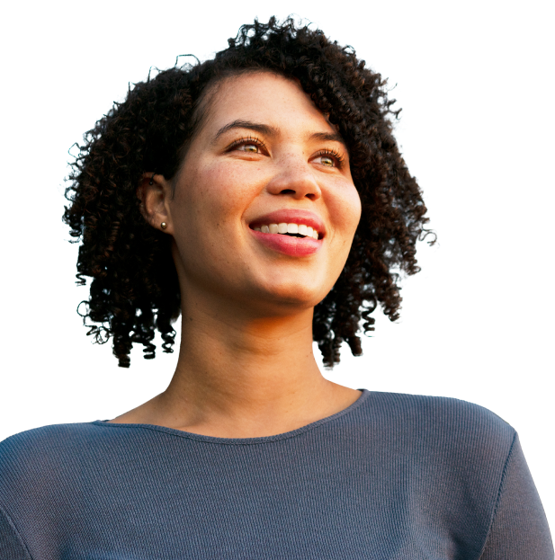 Young woman with dark curly hair looks into the distance with an optimistic smile.